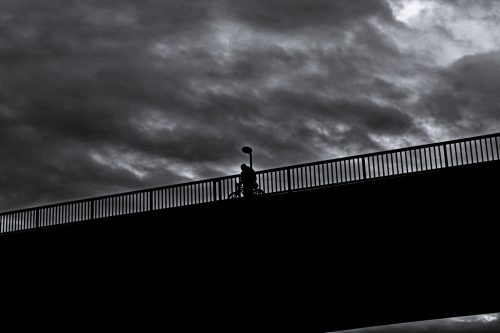 Angers silhouette poussant son vélo sur le pont de basse chaine